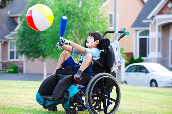 Handicap jongen slaan bal met bat in park — Stockfoto