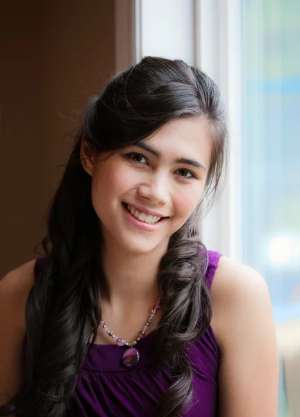Schöne birassische junge Frau lächelt am Fenster — Stockfoto