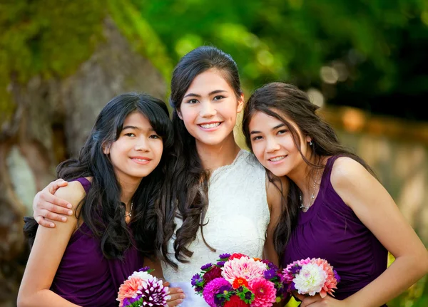 Novia con sus dos damas de honor sosteniendo ramo al aire libre juntos — Foto de Stock