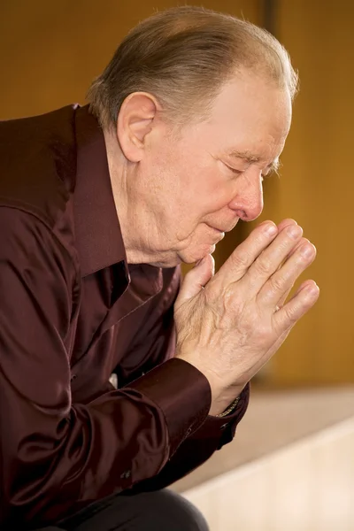 Oudere man in de kerk bidden — Stockfoto