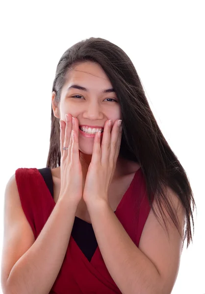 Bela menina adolescente bi-racial em vestido vermelho animado, mãos no rosto — Fotografia de Stock