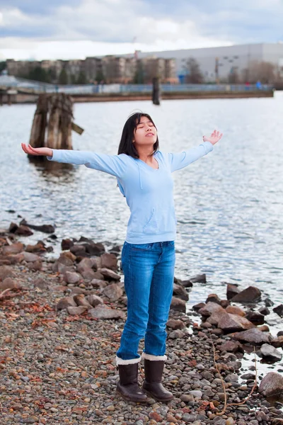 Young teen girl with arms lifted and outstretched, praising God — Stock Photo, Image