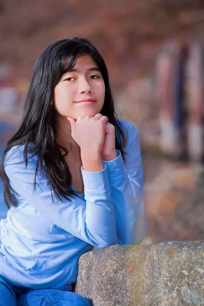 Joven adolescente biracial chica tranquilamente descansando codos en la roca a lo largo de la — Foto de Stock