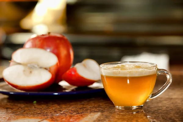 Glass cup of freshly juiced apple on kitchen counter next to pla — Stock Photo, Image