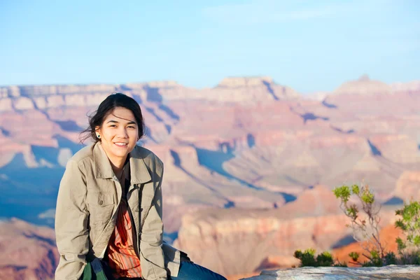 Giovane ragazza adolescente seduta sul bordo roccioso al Grand Canyon — Foto Stock