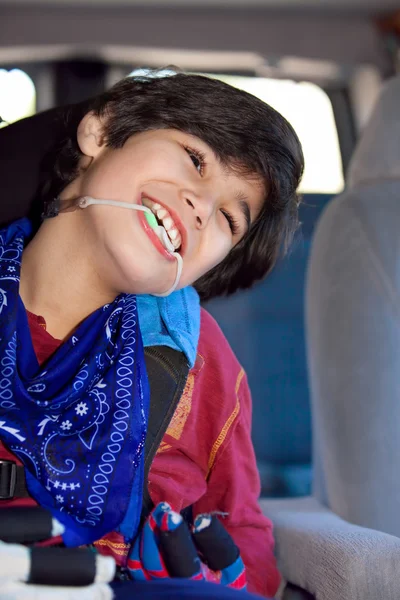 Disabled little boy sitting in carseat inside vehicle — Stok fotoğraf