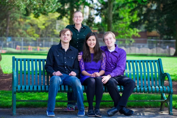 Quatro jovens amigos multiétnicos juntos no parque — Fotografia de Stock