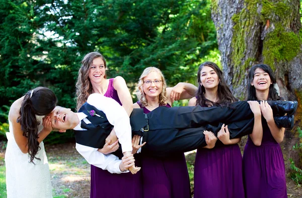 Fyra tärnor bära brudgummen i famnen — Stockfoto
