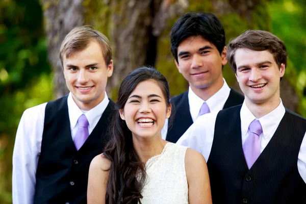 Bruid permanent met haar drie groomsmen buitenshuis onder grote tre — Stockfoto
