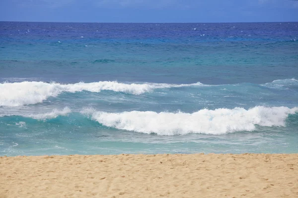 Aguas azules y olas en una playa hawaiana en un día soleado — Foto de Stock