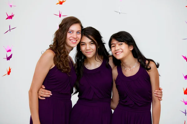 Três lindas meninas adolescentes juntas em vestidos pruple combinando Imagem De Stock