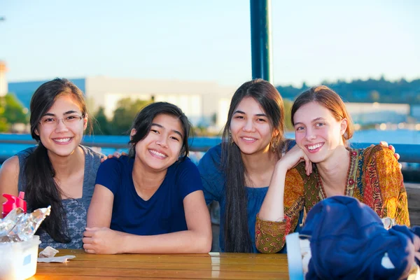 Grupp fyra unga kvinnor ler tillsammans vid sjö — Stockfoto