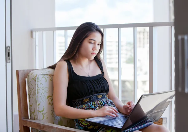 Biracial teen girl auf hochhaus terrasse mit laptop computer — Stockfoto