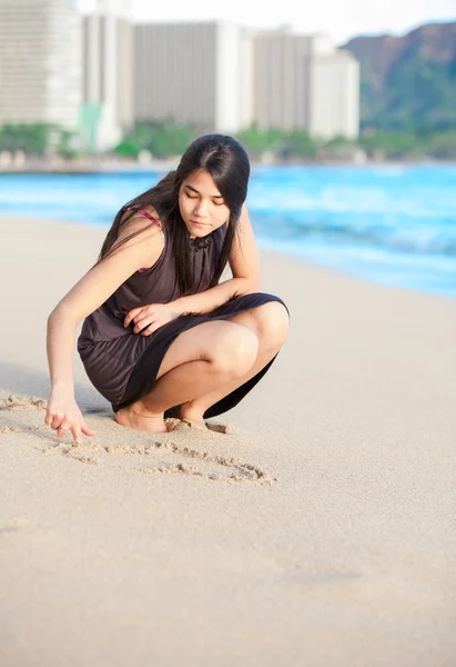 Gadis remaja kelahiran di pantai Waikiki menggambar di pasir — Stok Foto