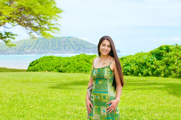 Teen flicka stående på frodiga gröna gräsmattan vid havet i Hawaii — Stockfoto