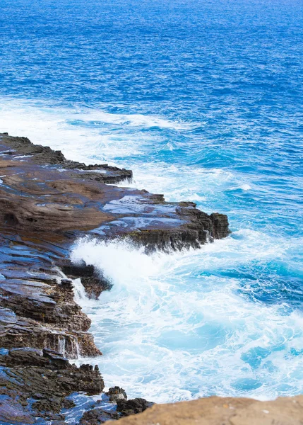 Bella acqua blu oceano colpire contro bordo roccioso — Foto Stock