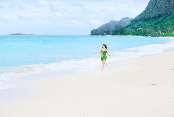 Hermosa chica adolescente en vestido verde corriendo en la playa hawaiana — Foto de Stock