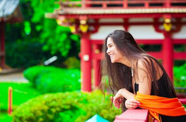 Teen girl  at a red Japanese or Chinese Bhuddist temple