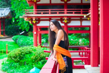 Teen girl  at a red Japanese or Chinese Bhuddist temple