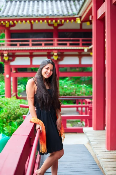 Teen girl  at a red Japanese or Chinese Bhuddist temple — Stock fotografie