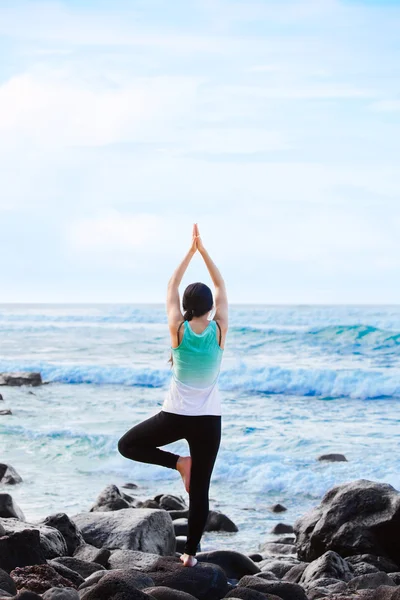 Biracial tonåring står på rock av ocean gör yoga — Stockfoto