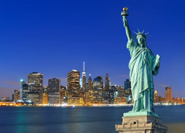 Manhattan bei Nacht und Freiheitsstatue. — Stockfoto