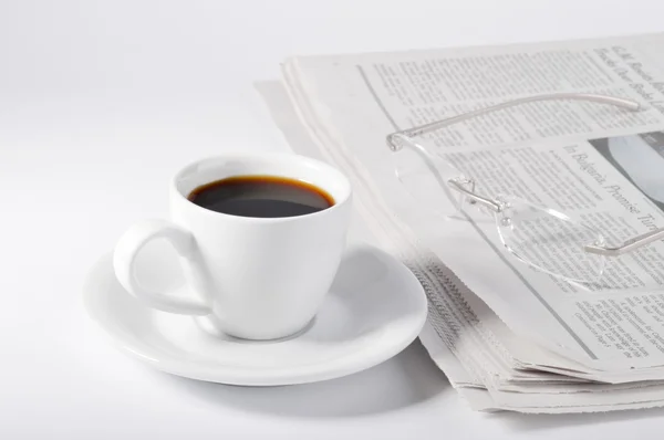 Una taza de café, vasos y periódico . — Foto de Stock