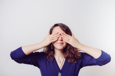 Kadın elini yüzünü kapatıyor.