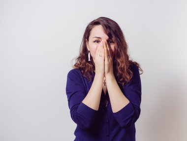 Kız gülüyor ve ağzını kapatıyor.