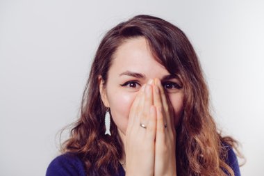 Kız gülüyor ve ağzını kapatıyor.