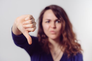 Kadın baş parmak hareketi gösteriyor.