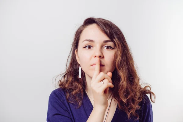Vrouw stak vinger op haar lippen — Stockfoto