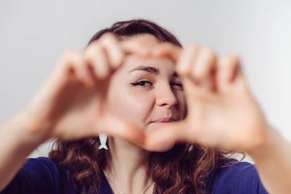 Mujer haciendo una mano corazón marco — Foto de Stock