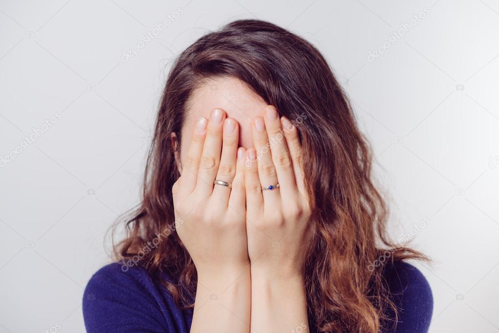 Woman covers his face by hand