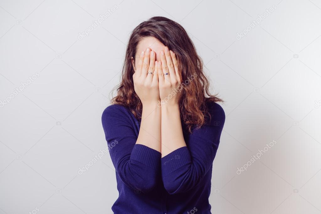 Woman covers his face by hand