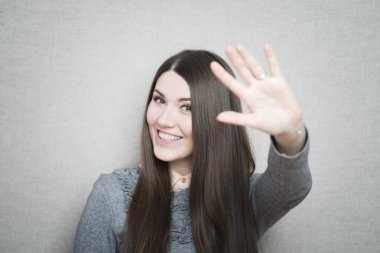 Genç kadın el sallıyor.