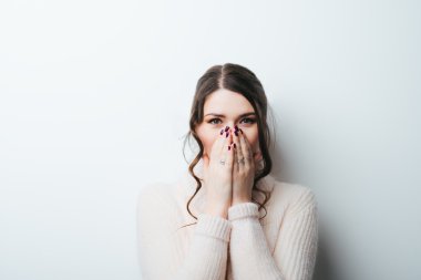 Kız ağzını elleriyle kapsar 