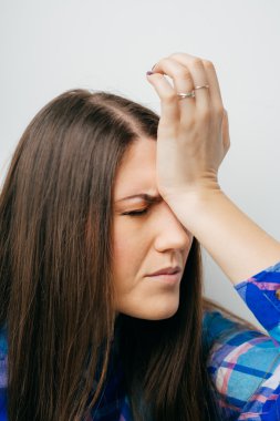 Kız elini kafasına atıyor.