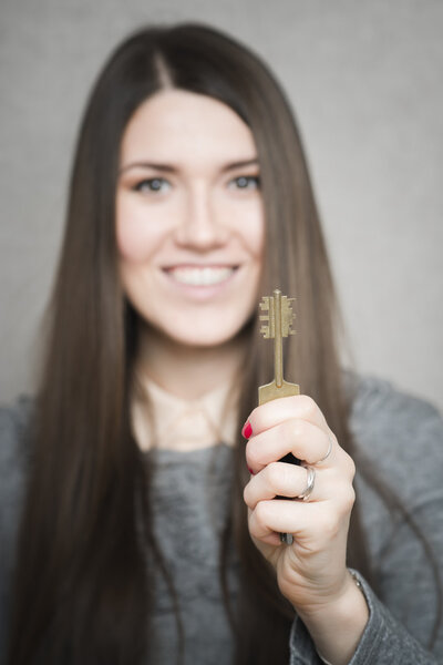 Женщина показывает ключ
