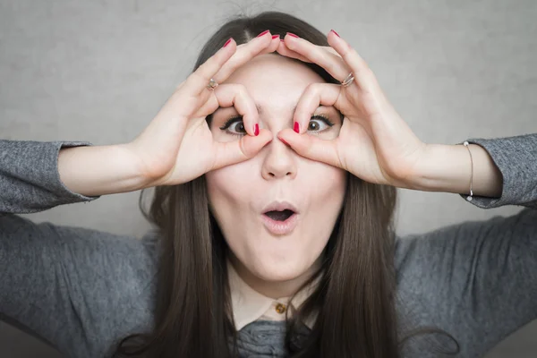 Mädchen schaut durch Finger — Stockfoto