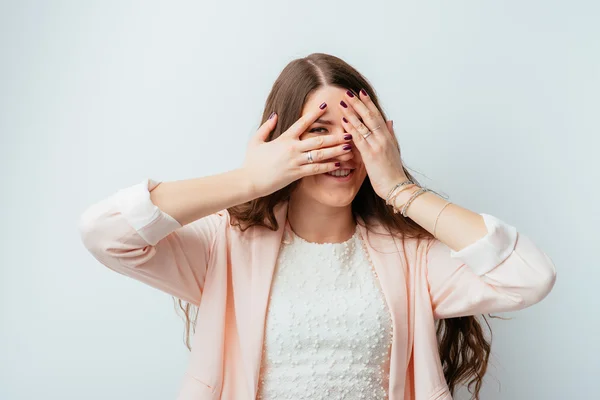 Frau blickt durch Finger — Stockfoto