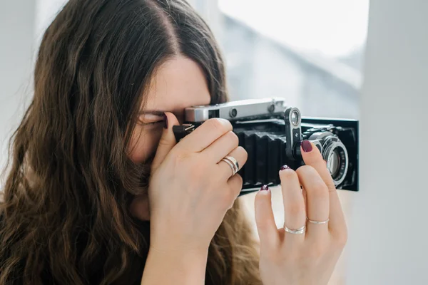 Brunett tjej med retro kamera — Stockfoto