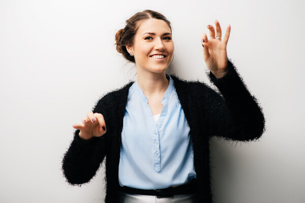 Девушка держит пальцами что-то
