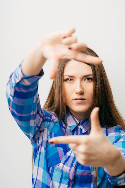 Femme montre cadre avec les doigts — Photo