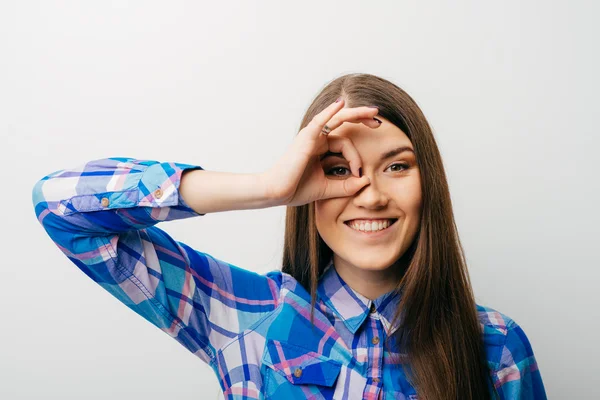 Woman looking through fingers — Stock Photo, Image