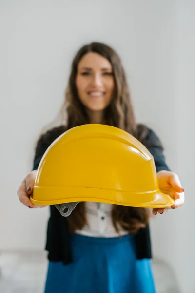 Menina segurando um capacete de construção — Fotografia de Stock
