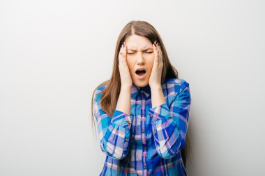 Baş ağrısı olan genç bir kadın.
