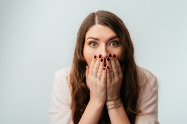 Kız ağzını elleriyle kapsar