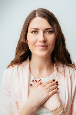 kız ellerini göğsüne koyar.