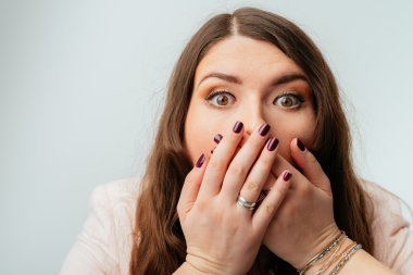 Kız ağzını elleriyle kapsar